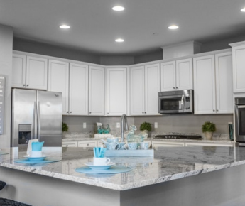 A shining white kitchen with beautiful granite countertops