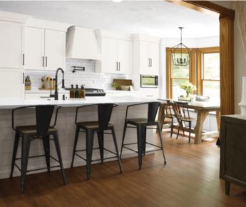 A beautiful cozy kitchen with white cabinets and inviting barstools